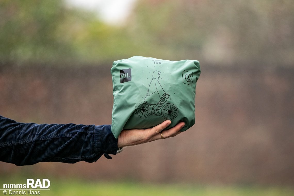 Verpackt in seiner eigenen Brusttasche kann der BTWIN Regenponcho transportiert werden.