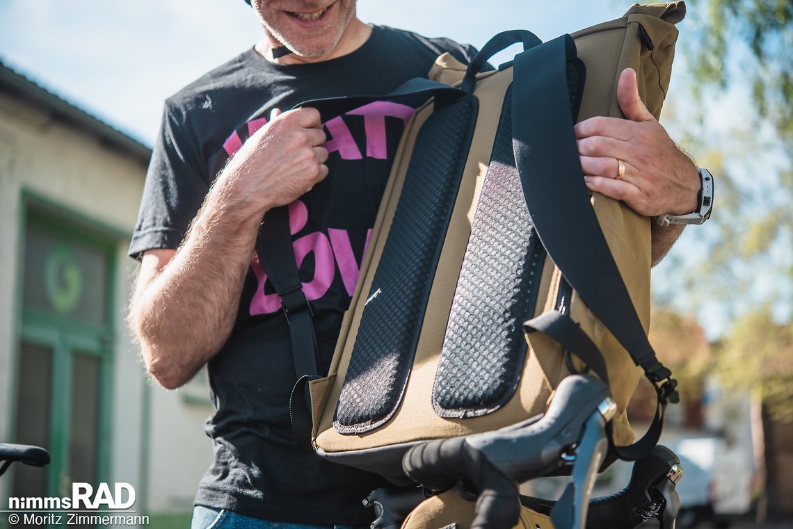 Der Messenger Bag-Rucksack bietet ein zweigeteiltes Rückenpolster für Tragekomfort und Ventilation.